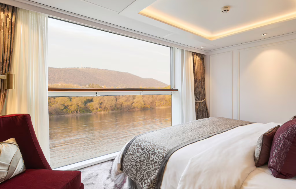 Riverside Luxury Cruises setzt auf Suiten statt klassischer Kabinen. Das Bild zeigt eine Suite an Bord der Riverside Debussy mit Panoramablick auf die Flusslandschaft